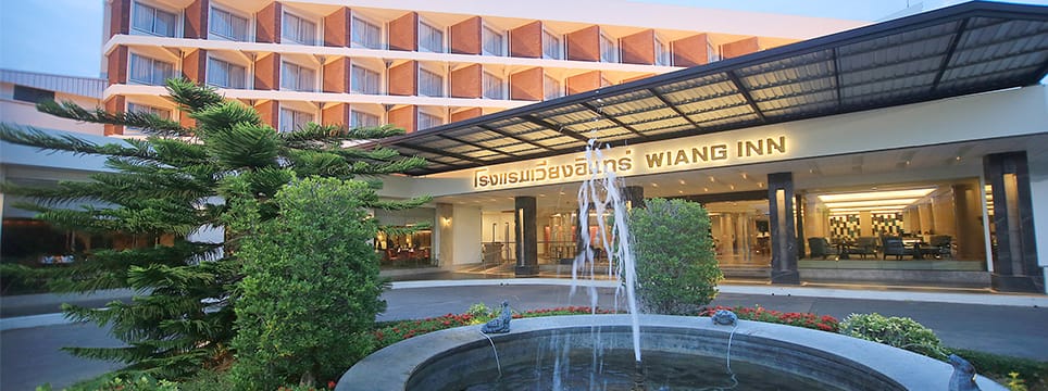 ด้านหน้าทางเข้า Wiang Inn Hotel พร้อมน้ำพุและป้ายโรงแรม