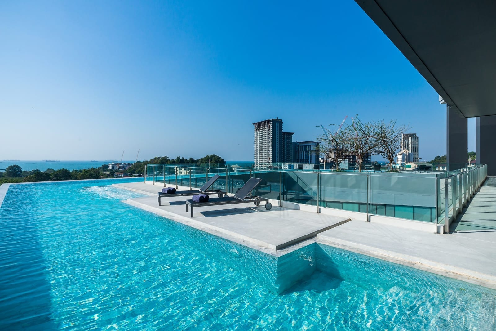 สระว่ายน้ำกลางแจ้งบนชั้น 5 ของ Arize Hotel Sri Racha มองเห็นวิวเมืองและอ่าวศรีราชา