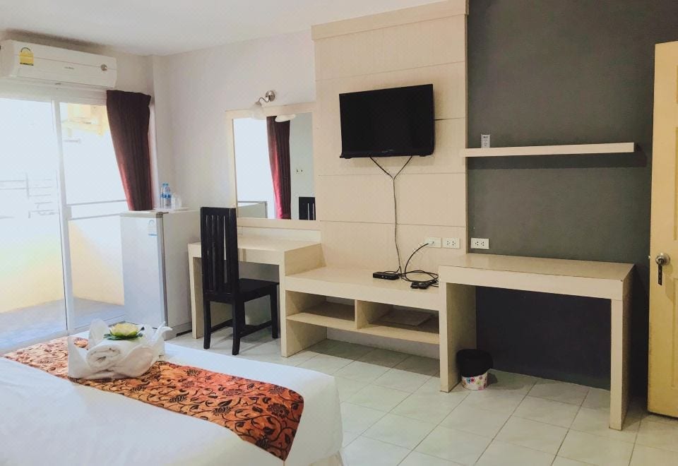 ห้องพักของ Grand Esie Service Apartment ปลวกแดง ตกแต่งเรียบง่ายพร้อมเตียงและระเบียงส่วนตัว