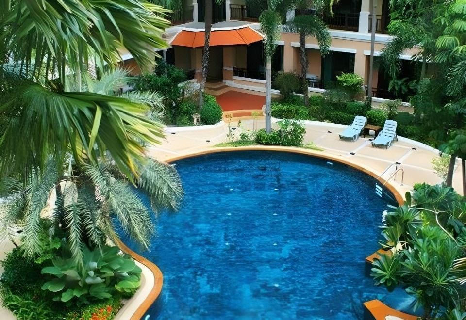 สระว่ายน้ำกลางแจ้งพร้อมจากุซซี่และสวนของ Le Casa Bang Saen Hotel ล้อมรอบด้วยอาคารห้องพัก