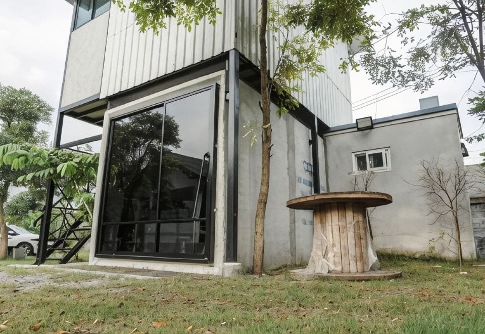 บรรยากาศสวนและที่จอดรถส่วนตัวหน้าห้องของ Patoey House ย่านนาป่า