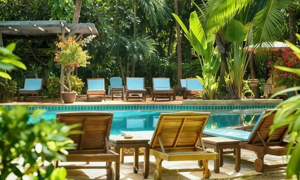 สระว่ายน้ำกลางแจ้งของ Rabbit Resort Pattaya ล้อมรอบด้วยต้นไม้ใหญ่ในสวน