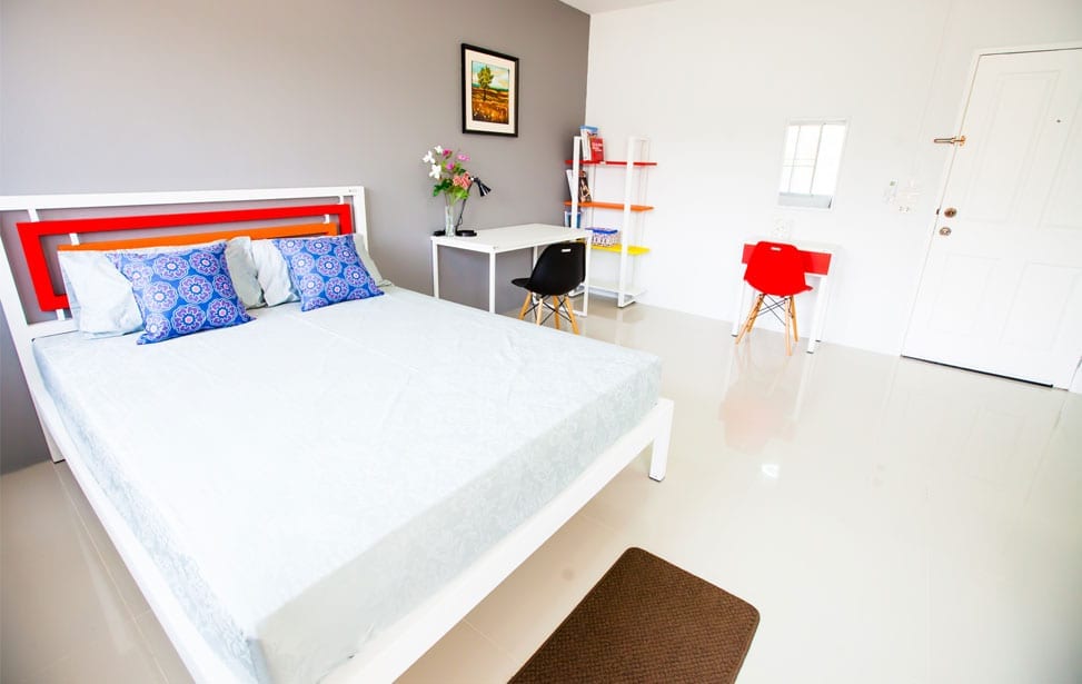 ห้องพัก Room 9 Residence ปลวกแดง ตกแต่งครบพร้อมเข้าอยู่ มีเตียง โต๊ะ และมุมครัวเล็ก