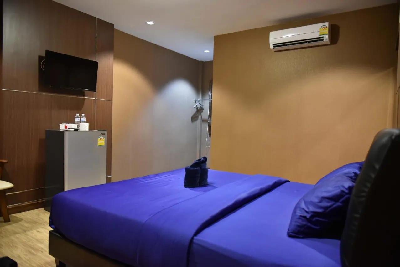 ห้องพักติดแอร์ของ SiriNiran Resort สัตหีบ ตกแต่งเรียบง่ายสะอาดตา พร้อมตู้เย็นและทีวี