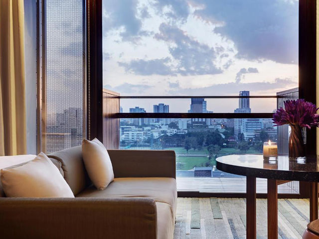 ห้อง Horizon Suite ของ Hansar Bangkok หน้าต่างพาโนรามาวิวสนามกรีฑาสโมสรสีเขียวยามเย็น
