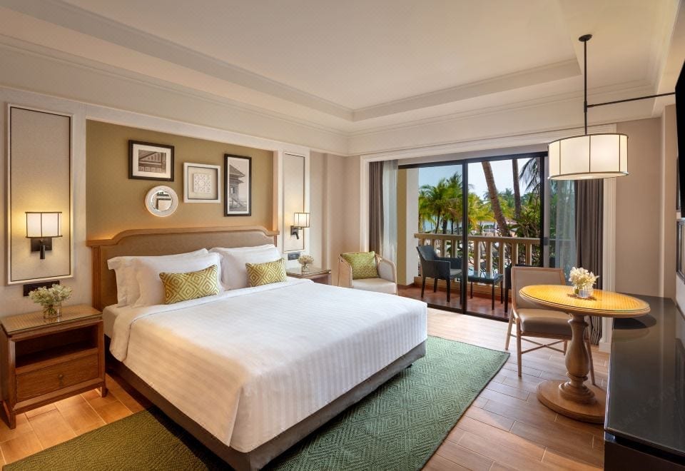 ห้องพักของ Dusit Thani Hua Hin ตกแต่งด้วยงานไม้โทนอบอุ่นพร้อมเตียงใหญ่และระเบียงส่วนตัว