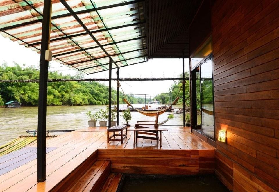 ห้องพักแพลอยน้ำของ Boutique Raft Resort พร้อมระเบียงไม้ยื่นเหนือแม่น้ำแควน้อย