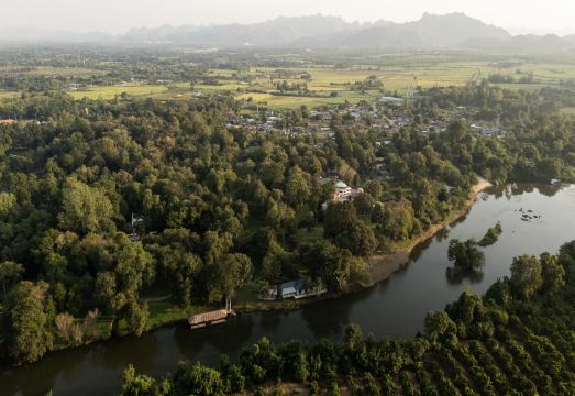 สระว่ายน้ำกลางแจ้งของ Comsaed River Kwai Resort ท่ามกลางสวนเขียวและแนวภูเขา