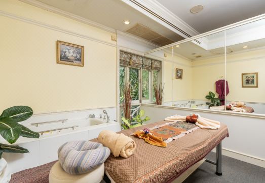 ห้องพักโทนไม้พร้อมระเบียงส่วนตัวมองวิวสวนและแม่น้ำของ Comsaed River Kwai Resort