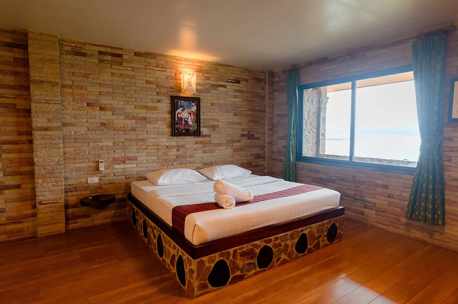 มุมห้องพักโทนไม้ของ P Guesthouse มองออกไปเห็นทะเลสาบและหมู่บ้านมอญ