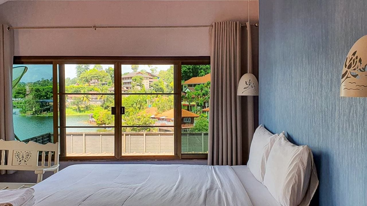 ห้องพักริมน้ำของ Pornpailin Riverside Resort พร้อมระเบียงส่วนตัวมองเห็นแม่น้ำและสะพานไม้