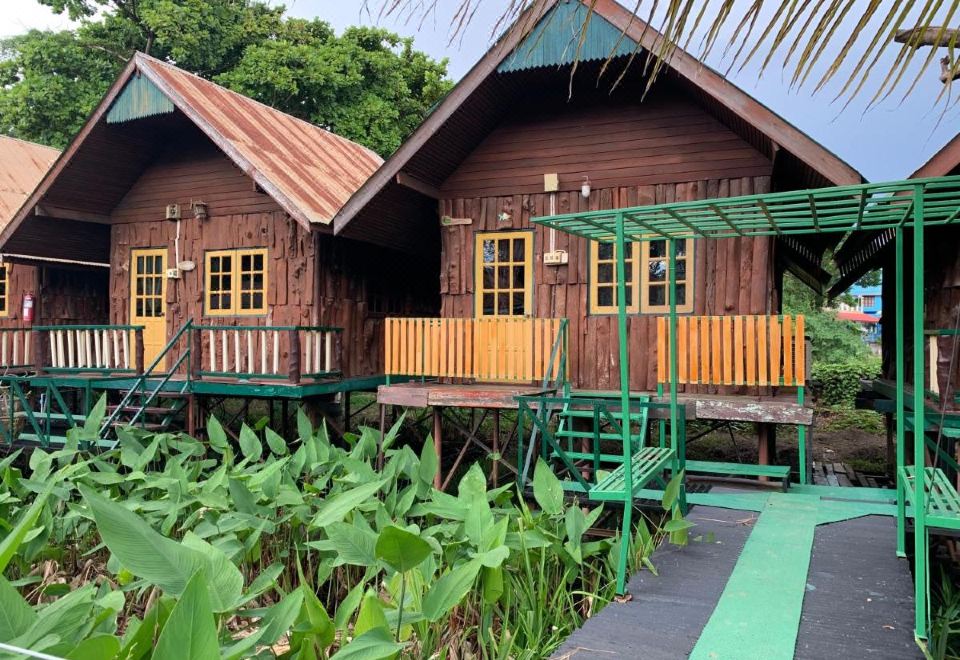 ห้องพักภายในของ Sam's House โทนไม้ เตียงคู่และมุมนั่งเล่นเรียบง่าย