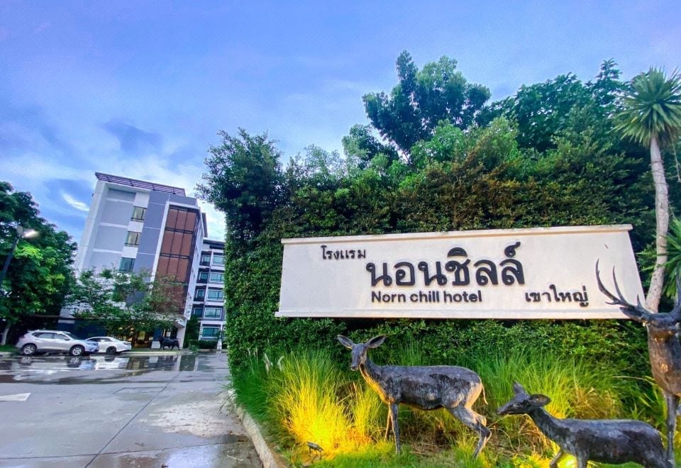 A Nornchill Khaoyai room with simple, bright decor, a big clean bed, AC and a flat-screen TV