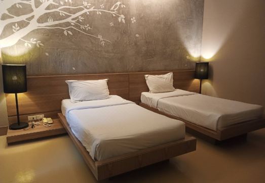 ห้องพักตกแต่งเรียบ พร้อมเตียงและพื้นที่นั่งเล่นภายในรีสอร์ท