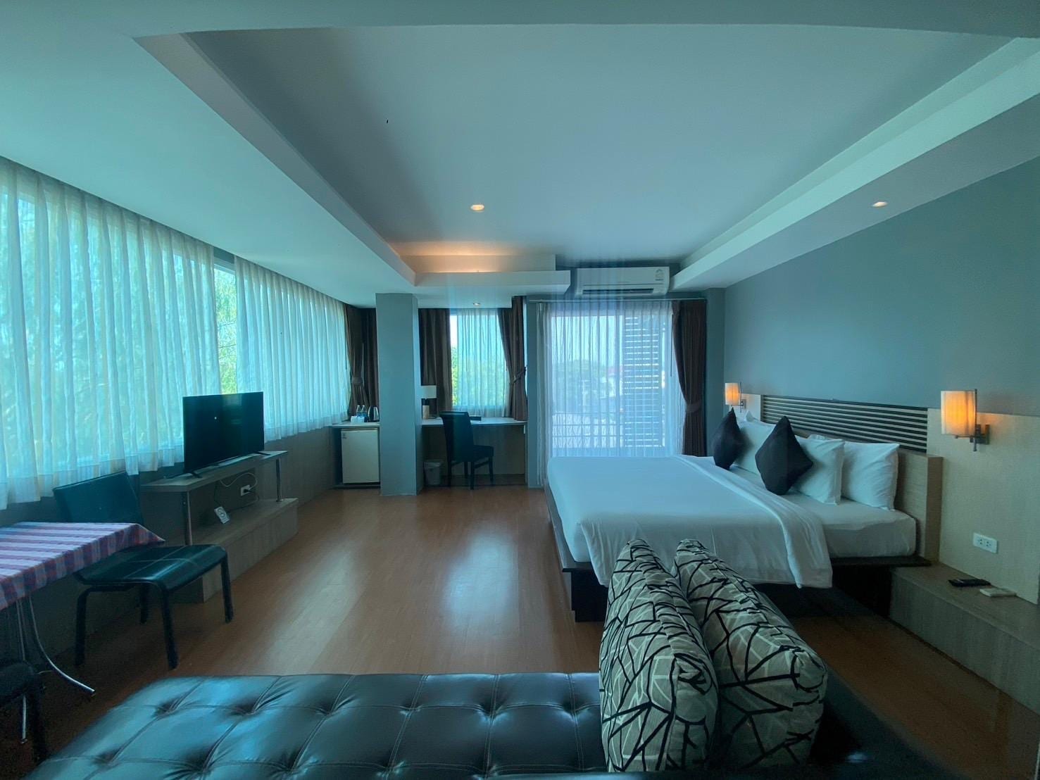 ห้องพักกว้างขวางของ Green Hotel & Resort Khon Kaen เตียงใหญ่ โซฟา และหน้าต่างบานยาวรับแสง