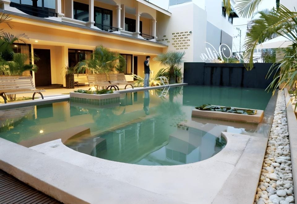 สระว่ายน้ำกลางแจ้งของ Hotel La Villa Khon Kaen ที่มีห้องพักจัดวางล้อมรอบ พร้อมต้นไม้เขียว