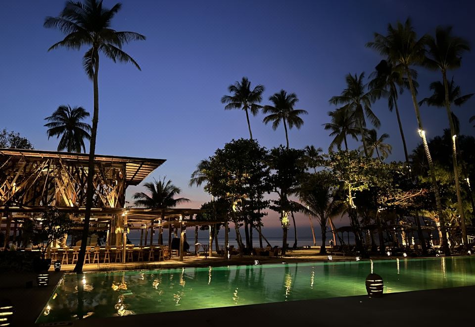 The long lap pool of The Emerald Cove Koh Chang stretching through beachfront gardens