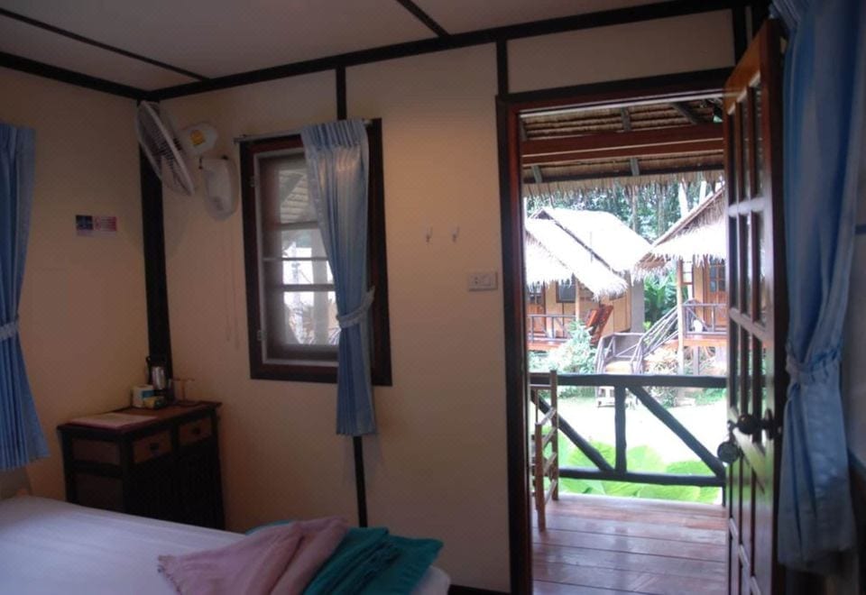 Wooden and woven-bamboo bungalows with thatched roofs at Jungle Garden, set in a shady garden in the Ao Bai Lan area of Koh Chang