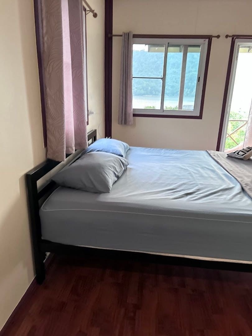 A bay-view bungalow room at Ao Salat View Koh Kood with a bed and a window looking out over Ao Salat bay