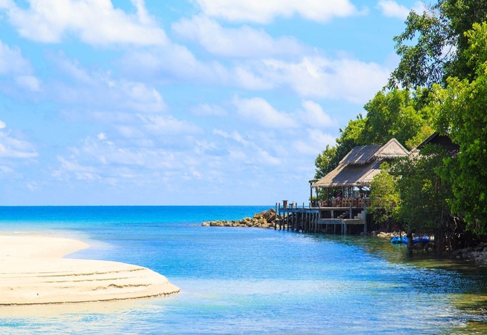 Private white-sand beach with clear water at Captain Hook Resort on a Koh Kood headland