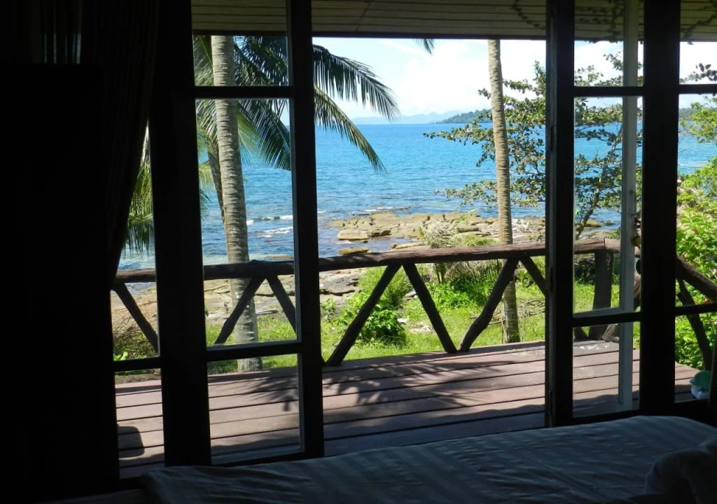 A Thai-style wooden bungalow at Horizon Resort Koh Kood with a private balcony facing the sea