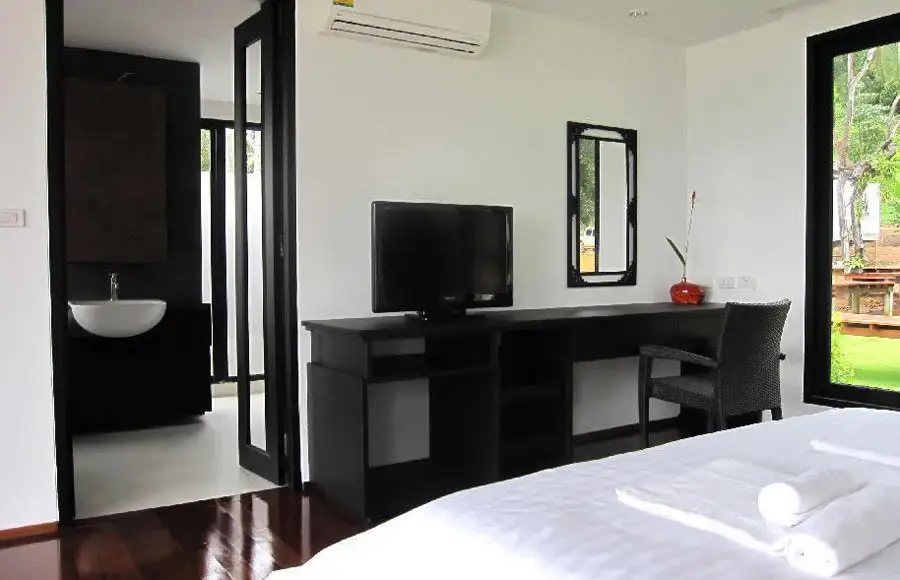 ห้องนอนภายในวิลล่าของ Plubpla Koh Mak Retreat ตกแต่งสไตล์โอเรียนทัลโทนไม้