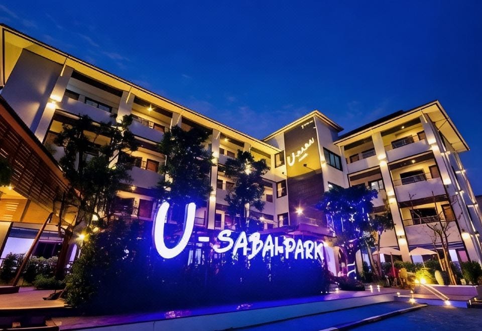 อาคารรีสอร์ตเตี้ยของ U-Sabai Park Resort โคราช ล้อมรอบด้วยสวนและที่จอดรถหน้าห้อง
