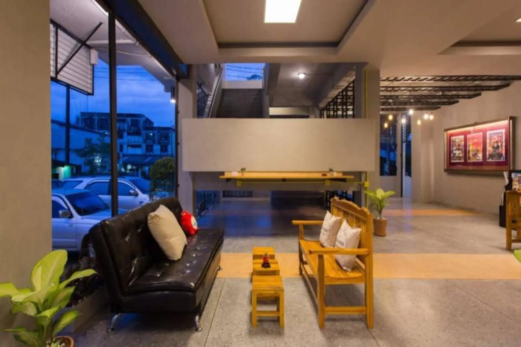 มุมส่วนกลางของ Holiday Station Hostel ตัวเมืองกระบี่ มีโต๊ะพูลและพื้นที่นั่งเล่น