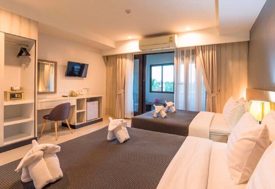 มุมห้องพักของ Lada Krabi Residence พร้อมทีวีจอแบน ตู้เย็น และโต๊ะ เหมาะพักช่วงเที่ยวเมืองกระบี่