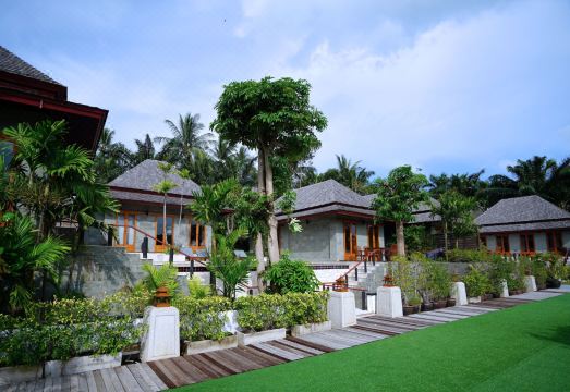 สระว่ายน้ำกลางแจ้งของ Nakamanda Resort มองออกไปเห็นสวนและทะเลอันดามัน