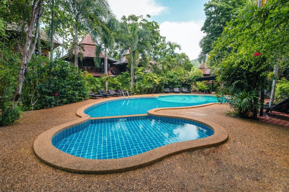 สระว่ายน้ำกลางแจ้งของ Phu Pha Aonang Resort & Spa ท่ามกลางสวนเขตร้อนร่มรื่นและวิวเขาหินปูน