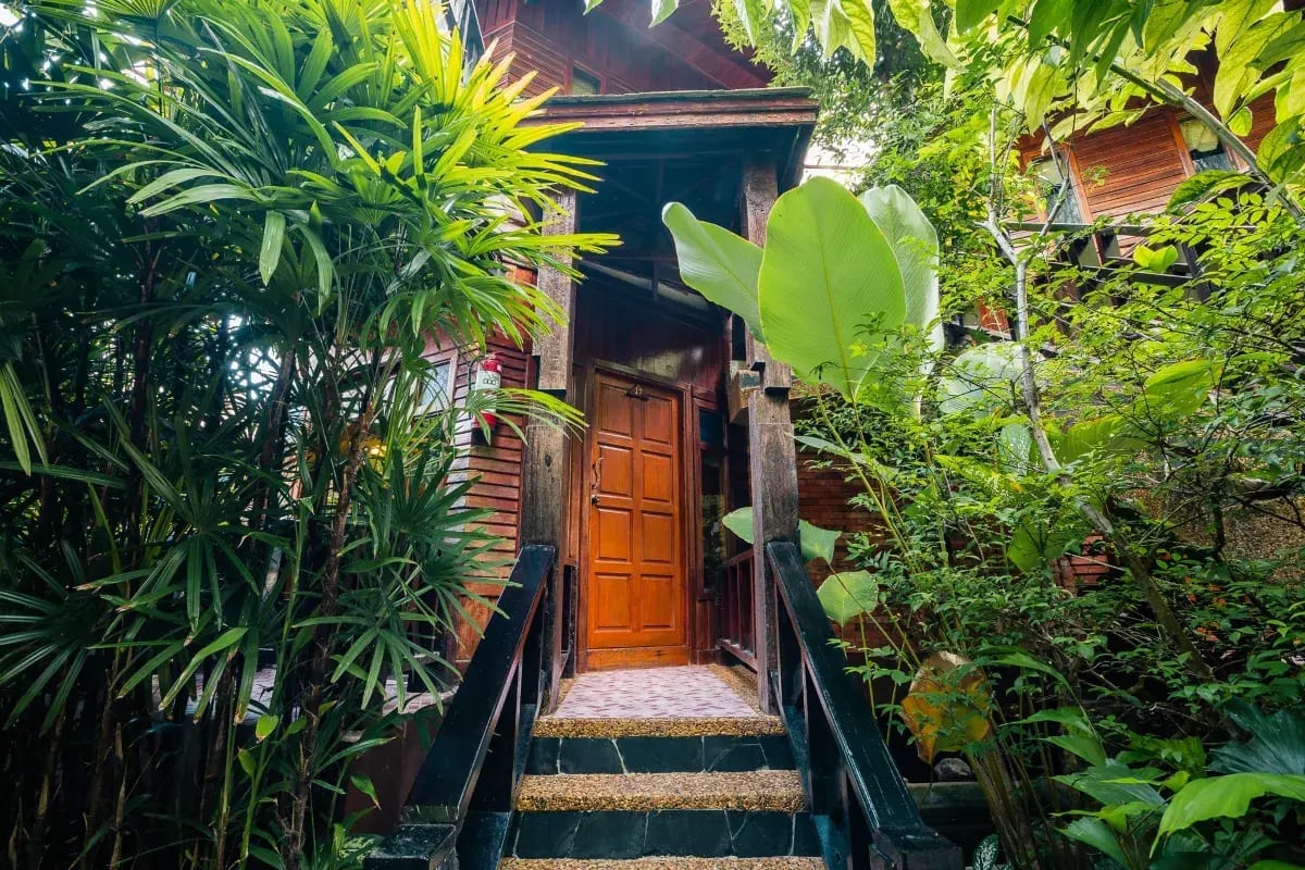 ห้องพักของ Phu Pha Aonang Resort & Spa ตกแต่งโทนไม้อบอุ่นพร้อมระเบียงมองสวน