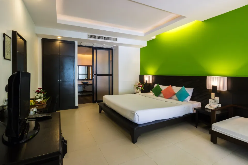 ห้องพักของ Sand Sea Resort ตกแต่งโทนไม้ มีเตียงและระเบียงส่วนตัว