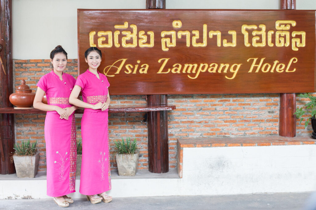 ห้องพักกว้างของ Asia Lampang Hotel โทนเรียบ มีเตียงและสิ่งอำนวยความสะดวกครบ