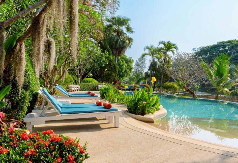สระว่ายน้ำกลางแจ้งของ Lampang River Lodge ท่ามกลางสวนต้นไม้ใหญ่ริมแม่น้ำวัง