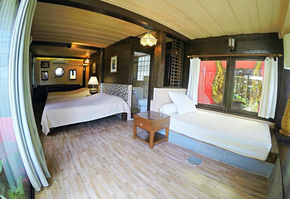 บรรยากาศเรือนไม้เก่าและสวนริมแม่น้ำวังของ The Riverside Guest House ลำปาง