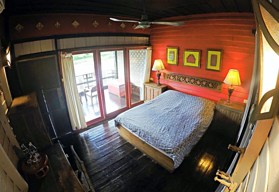 คาเฟ่และระเบียงนั่งชมแม่น้ำวังของ The Riverside Guest House โทนไม้อบอุ่น