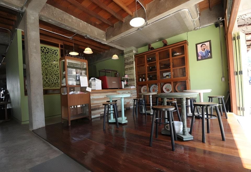 คาเฟ่และมุมทานอาหารเช้าชั้นล่างของ Muiphang Guesthouse ตกแต่งด้วยของเก่า ตู้ไม้วินเทจ และเก้าอี้สตูล