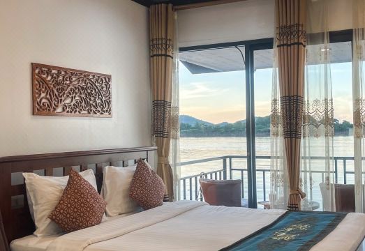 เรือนไม้ริมแม่น้ำโขงของ Riverside Chiangkhan Resort พร้อมระเบียงมองเห็นฝั่งลาว