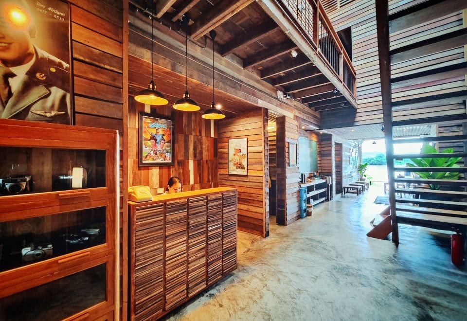 ล็อบบี้บ้านไม้เก่าของ Suneta Hostel Chiangkhan ตกแต่งด้วยผนังไม้เก่าและเคาน์เตอร์ไม้สไตล์เรโทร