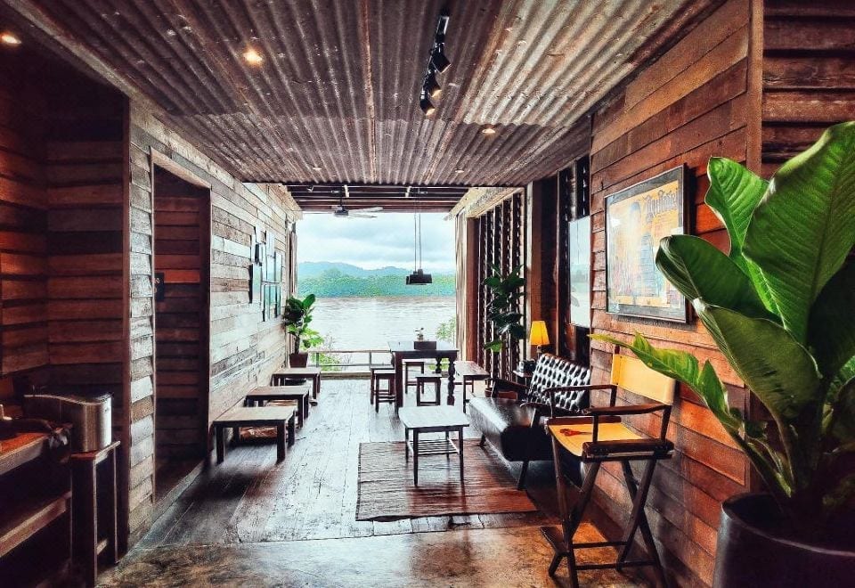 โซนนั่งเล่นริมน้ำของ Suneta Hostel เปิดออกเห็นแม่น้ำโขงและภูเขาฝั่งลาว