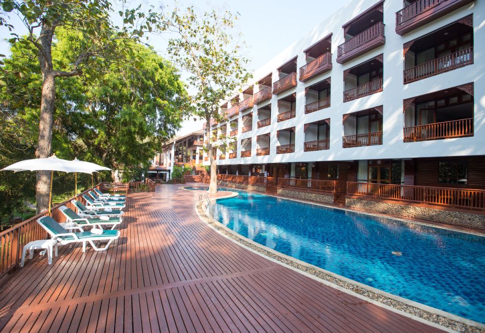 สระว่ายน้ำกลางแจ้งของ Imperial Mae Hong Son Resort ล้อมรอบด้วยต้นไม้เขียว