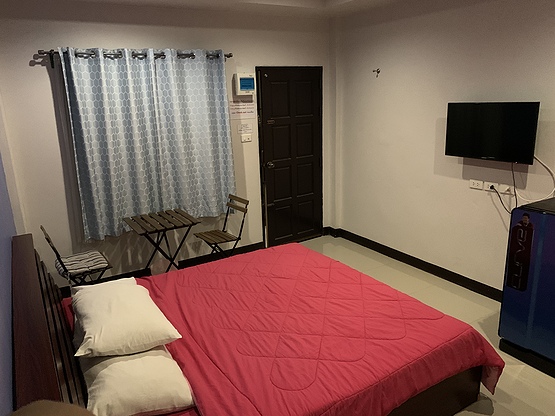 ห้องพักของ Kanya Place มหาสารคาม เตียงนุ่ม แอร์ ทีวีจอแบน และประตูออกระเบียง