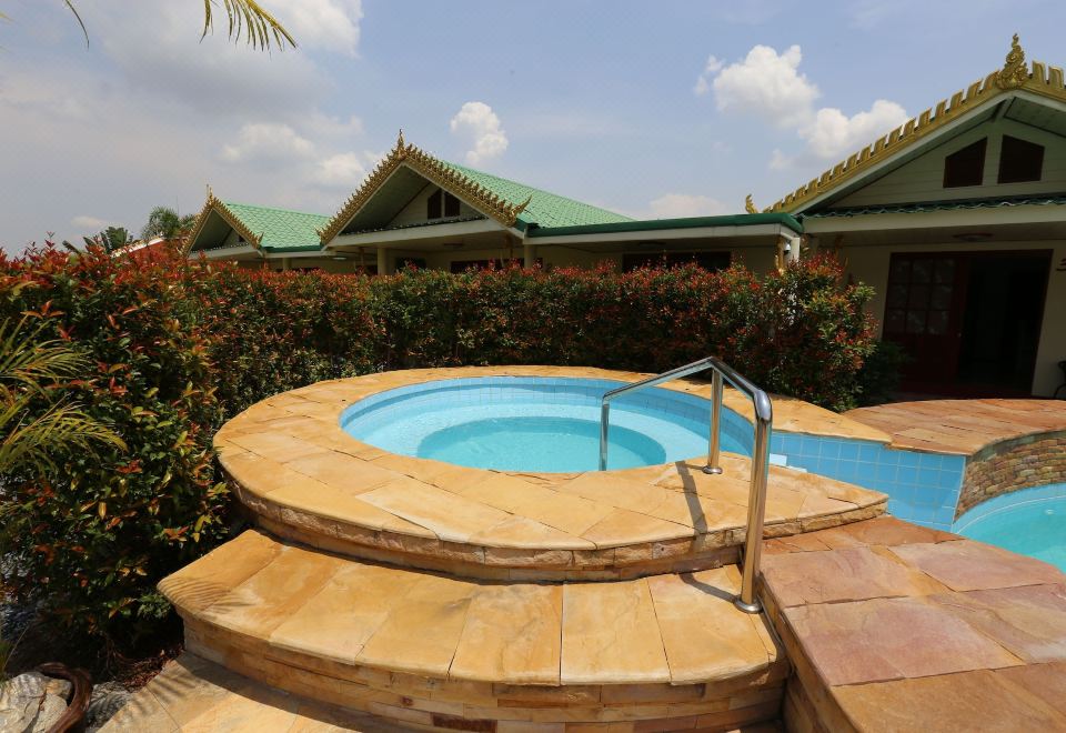 สระว่ายน้ำกลางแจ้งของ The Orchid Resort & Relax ล้อมด้วยสวนเขียว