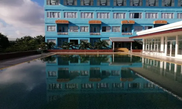 สระว่ายน้ำกลางแจ้งของ Taksila Hotel มหาสารคาม ล้อมรอบด้วยพื้นที่นั่งเล่น