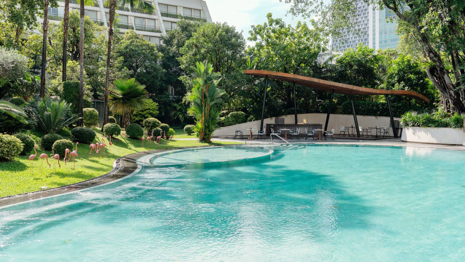 สระว่ายน้ำเกลือกลางสวนของ Mövenpick BDMS Wellness Resort Bangkok ล้อมรอบด้วยต้นไม้ใหญ่ Bliss Pool Bar