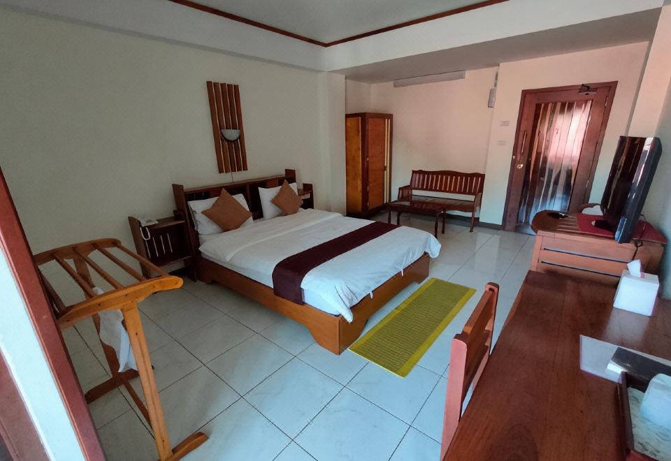 ห้องพักของ Riverfront Hotel Mukdahan พร้อมเฟอร์นิเจอร์ไม้และระเบียงส่วนตัว