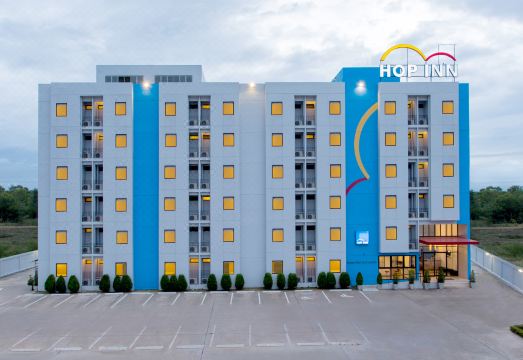 อาคารด้านหน้าของ Hop Inn Nakhon Pathom สีขาวเหลืองตามแบบเชน Hop Inn