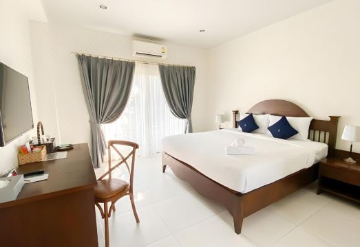 ห้องพักสีขาวสะอาดตาของ Koranaree Courtyard เตียงใหญ่ ระเบียงมองออกสวน