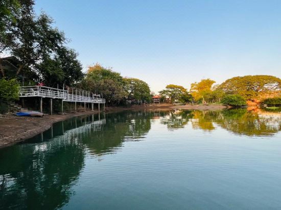 ระเบียงมีหลังคาของบังกะโลมองออกไปเห็นสายน้ำและสวนริมแม่น้ำมูล